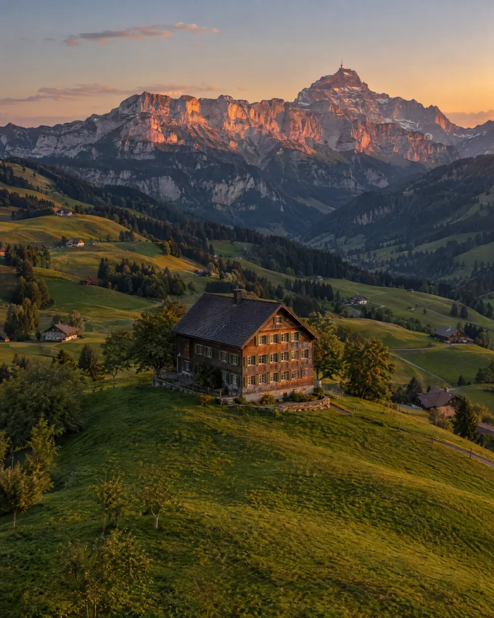 Gasthaus auf einer Appenzeller Hügelkuppe vor dem Alpstein mit Säntis im Abendlicht